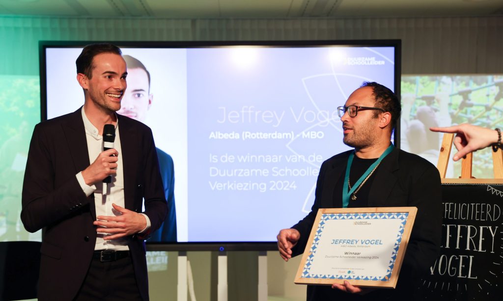 Winnaar Jeffrey Vogel van Albeda ontvangt een oorkonde tijdens de Duurzame Schoolleider Verkiezing 2024, waar schoolleiders worden gewaardeerd voor hun inzet voor duurzaamheid in het onderwijs