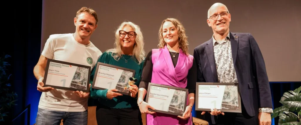 Vier winnaars van de Duurzame Docent Verkiezing 2025 poseren met hun oorkondes op het podium, als erkenning voor hun inzet om leerlingen voor te bereiden op een duurzame toekomst.