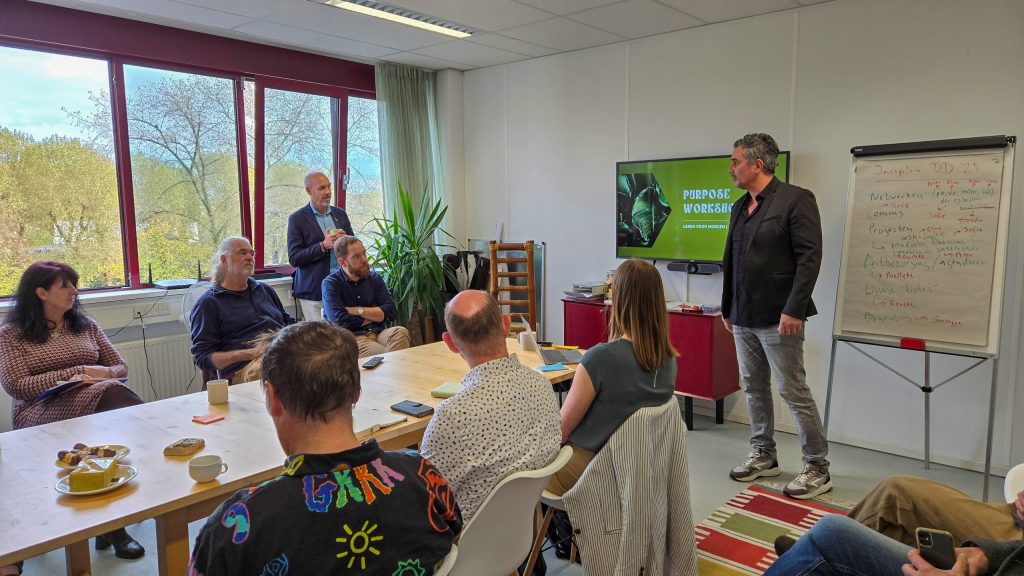Guido Bastiaans geeft een presentatie over de meerjarenstrategie van Leren voor Morgen tijdens de Algemene Ledenvergadering, waarbij leden meedenken over de koers van de coöperatie.