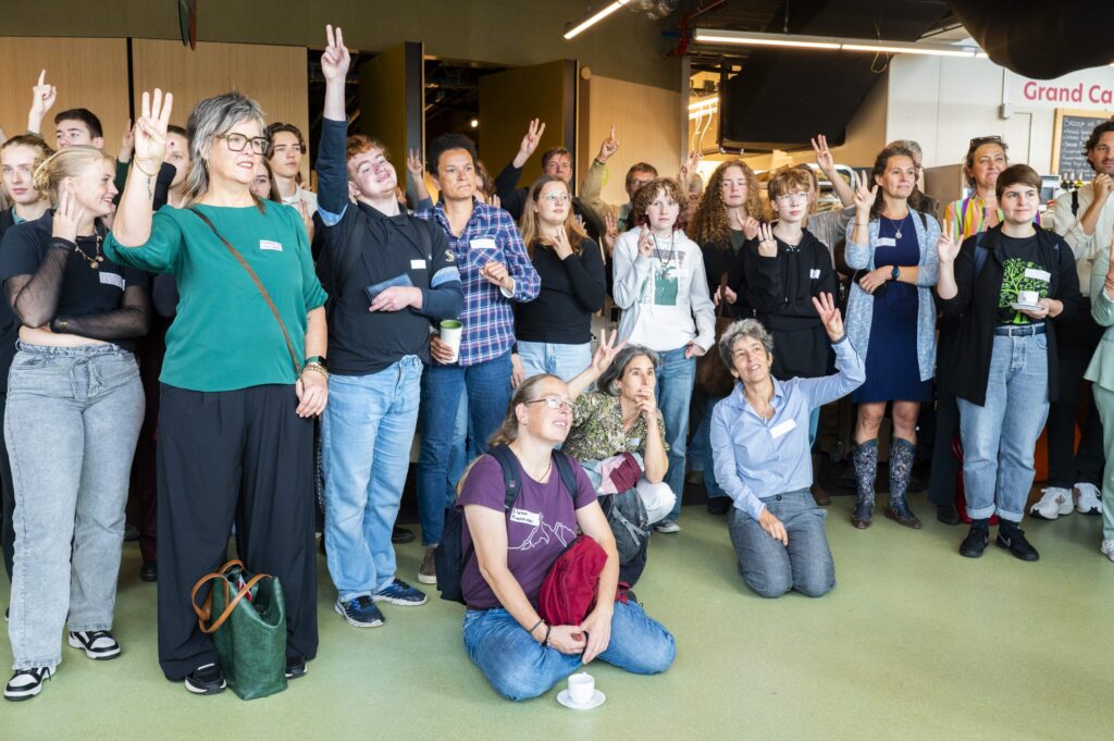 Groep deelnemers van het duurzaamheidsfestival 2025, een bijeenkomst over duurzaam onderwijs, enthousiast en betrokken bij een gezamenlijke activiteit.