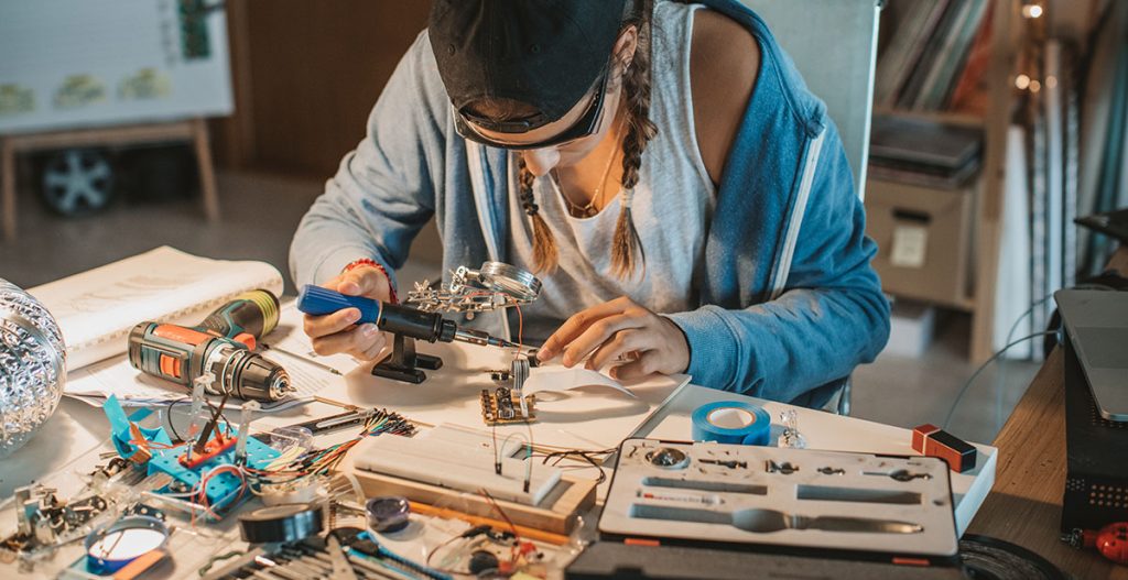 Student werkt geconcentreerd aan een technisch project met gereedschap en elektronica-onderdelen, symbool voor leren en innoveren binnen Sustainability Skills.
