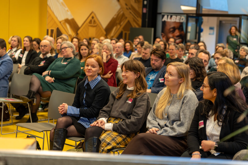 Deelnemers luisteren tijdens een bijeenkomst over duurzaam onderwijs in het mbo.